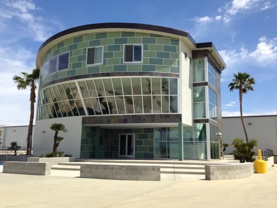 The curved glass building facade and broad entrance steps welcome visitors inside.